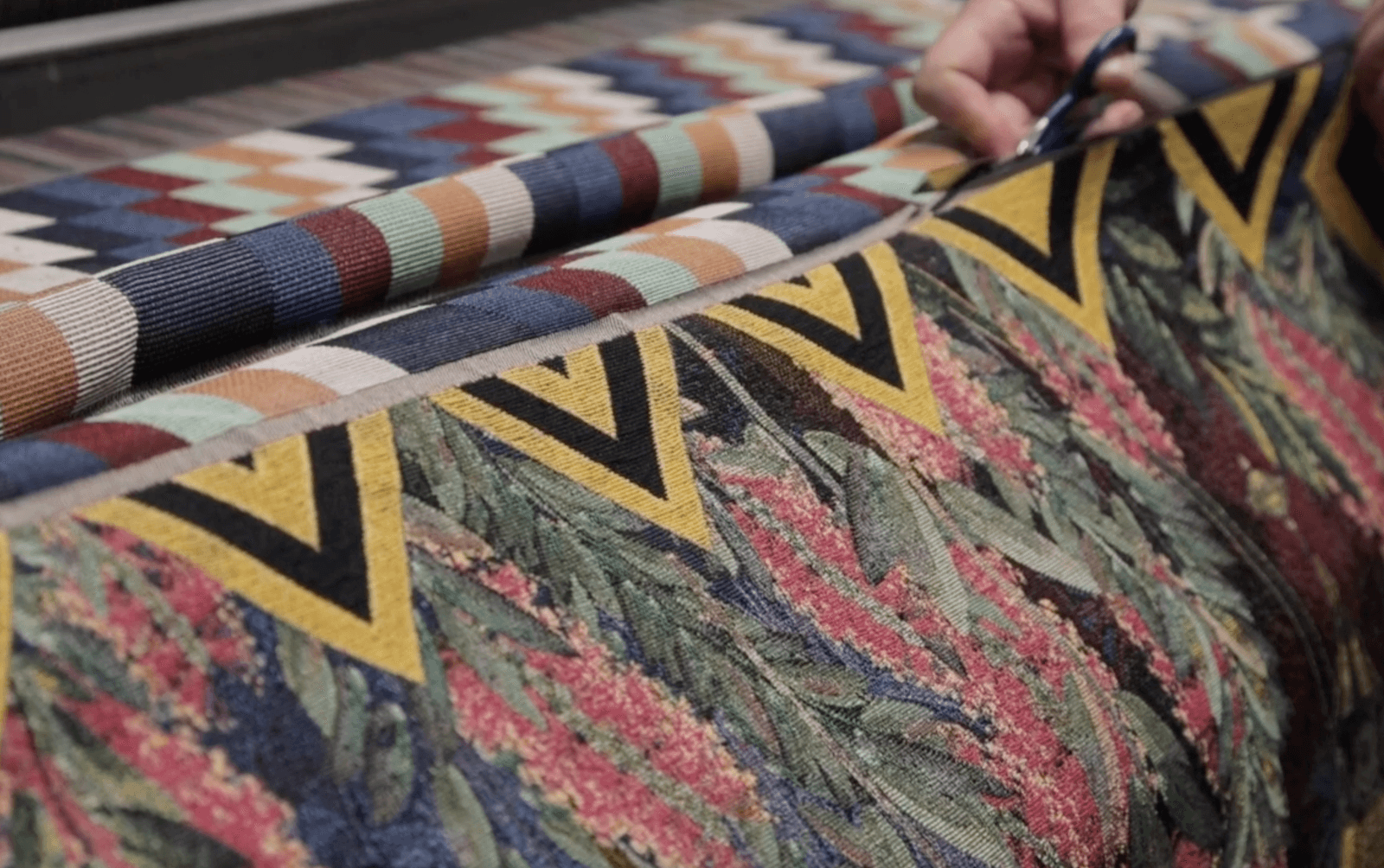 Artisan cutting woven tapestry