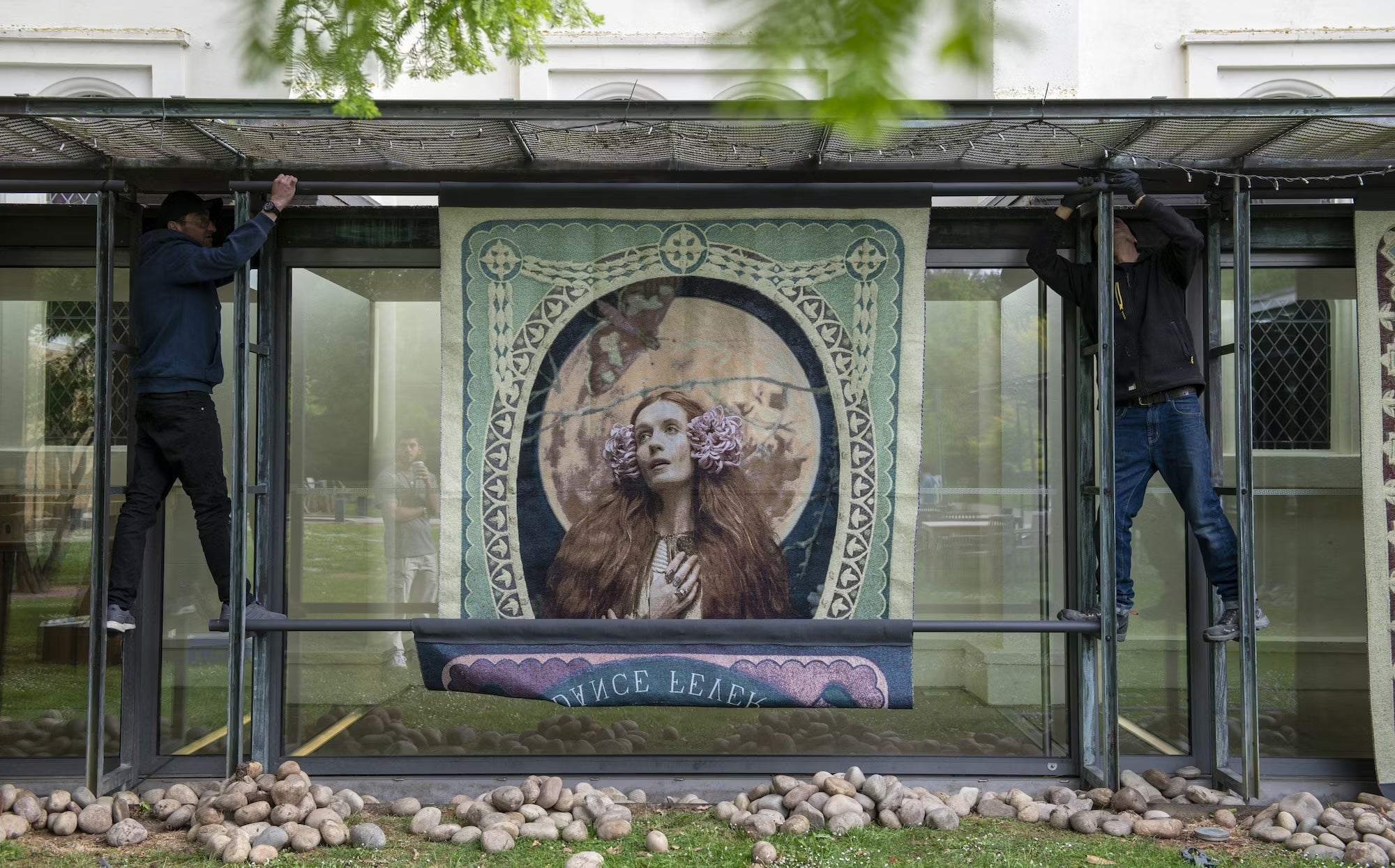 Large tapestry being installed